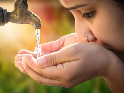 Girl drinking water from tap